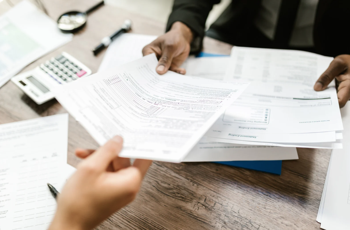 Documents being exchanged over an office table